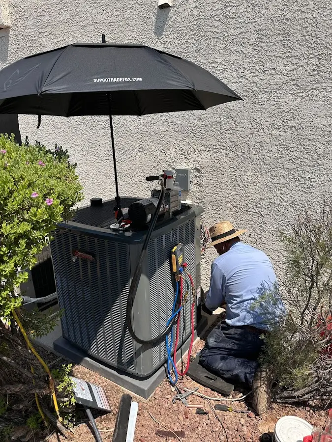 HVAC technician performing outdoor AC maintenance in Pensacola